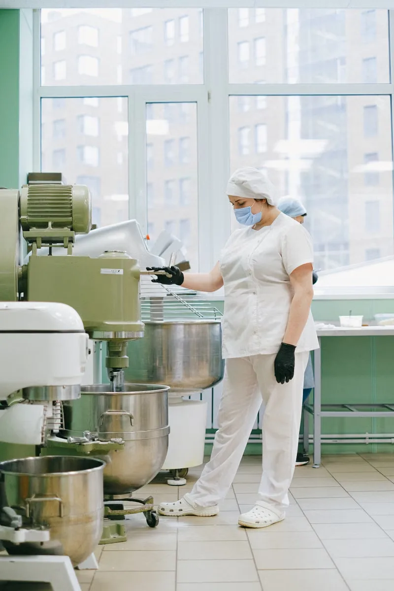 Food industry worker operating an industrial mixer
