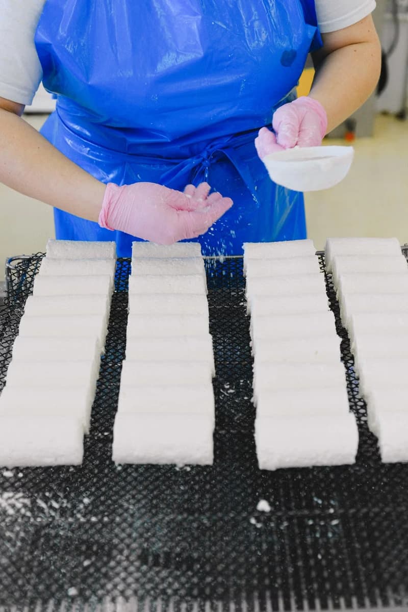Gloved hands preparing food products at a manufacturing facility