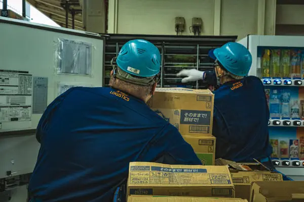 Workers handling logistics boxes in a warehouse