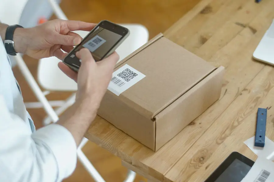 A customer scanning the QR code on a parcel with a smartphone